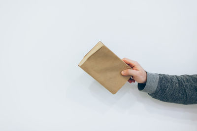 Person holding paper against white background