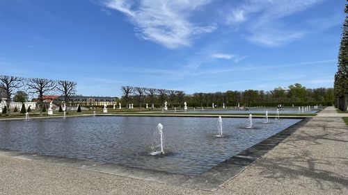 View of fountain in lake against cloudy sky