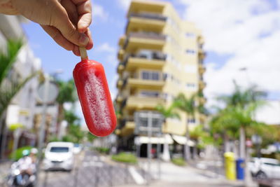 Midsection of man holding ice cream in city