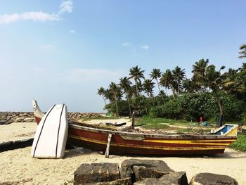 Boat moored on shore against sky