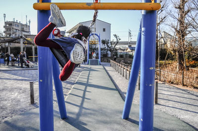 Rear view of girl swinging in playground