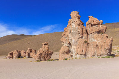 Rock formations in desert against blue sky