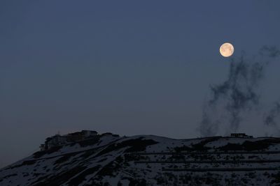 Scenic view of snowcapped mountains against sky at night