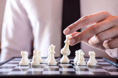 Midsection of businessman playing chess