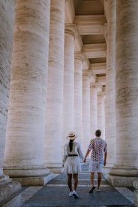 Full length rear view of woman walking in historical building