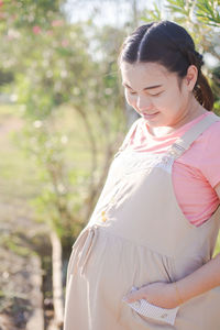 Pregnant woman standing in public park