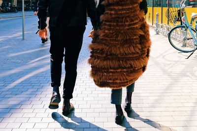 Low section of couple walking on street