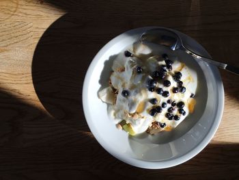 High angle close-up of breakfast in bowl with spoon on wooden table
