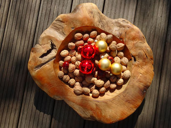 Christmas balls and nuts in a wooden bowl