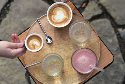 Cropped hand of man holding coffee on table