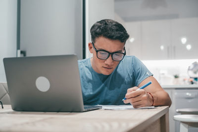 Young man using digital tablet at table