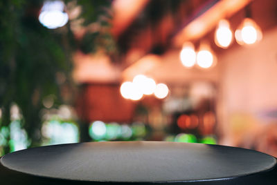 Close-up of empty black table in illuminated restaurant