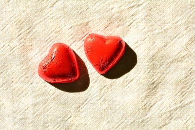 Close-up of red heart shape on sand