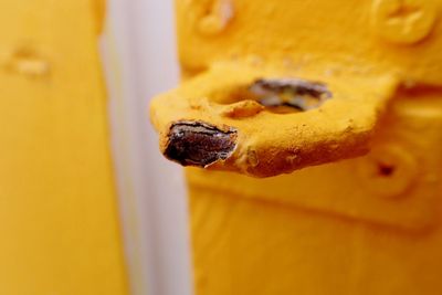 Close-up of rusty metallic damaged yellow latch