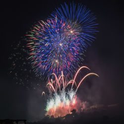 Low angle view of illuminated fireworks against sky at night