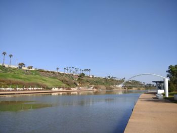 Bridge over river against clear blue sky