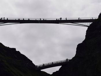 Low angle view of bridge against cloudy sky