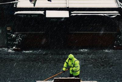 Rear view of man working in snow