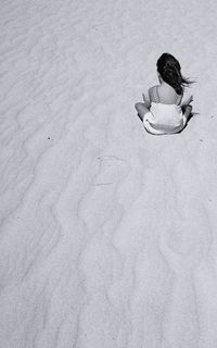 High angle view of girl sitting on sand