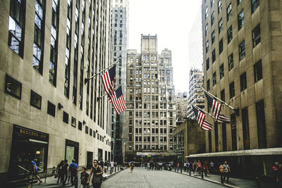 People on street amidst buildings in city