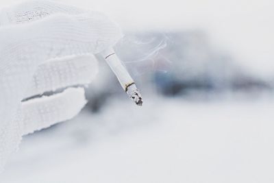 Close-up of hand holding cigarette