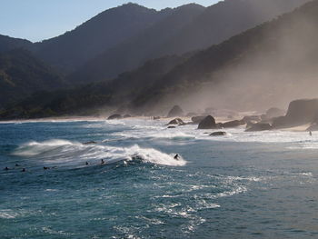 Scenic view of sea by mountains