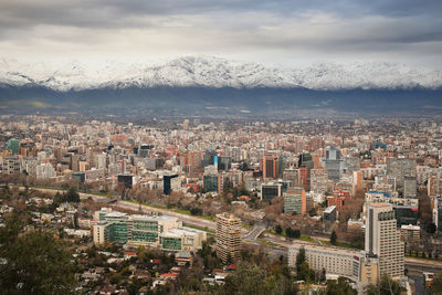 Aerial view of cityscape against cloudy sky