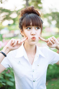 Portrait of young woman with eyes closed standing outdoors