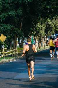 Rear view of men running in park