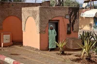 Rear view of man walking in front of building