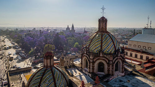 Aerial view of buildings in city against sky