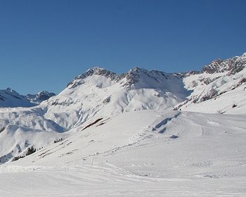 Scenic view of snowcapped mountains against blue sky