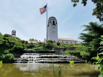 Gazebo over river amidst buildings against sky