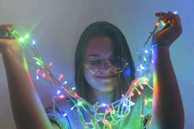 Close-up of smiling woman with illuminated lights