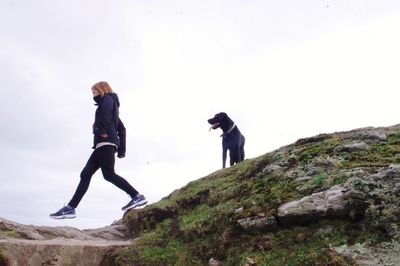 People on mountain against sky