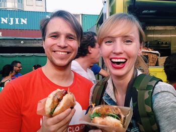 Smiling couple holding hamburgers