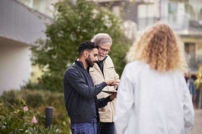 Two men with laptop in courtyard