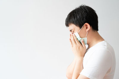 Side view of mature man using smart phone against white background