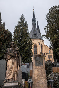 Sculpture in cemetery against sky
