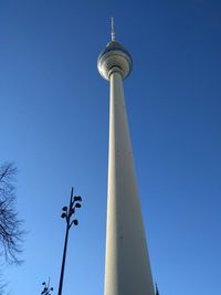 Low angle view of fernsehturm tower against blue sky