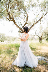 Woman with umbrella standing by tree