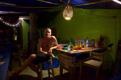 Portrait of shirtless man sitting at home