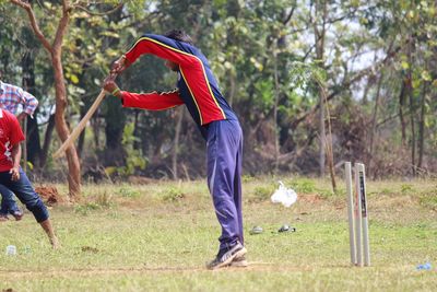 Man playing cricket on field