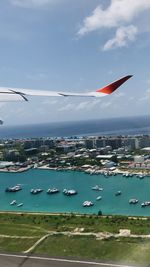 Aerial view of sea and cityscape against sky