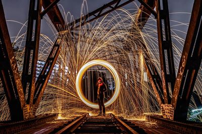 Full length of woman standing on bridge at night