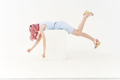 Full length of woman lying on white background