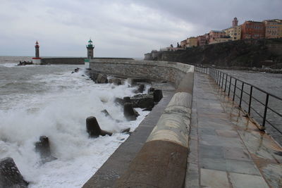 View of waves in sea against cloudy sky