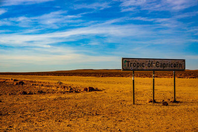 Signboard on landscape against the sky