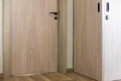 The wooden door with black metallic handle in new apartment.