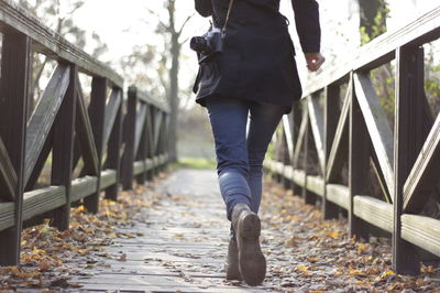 Rear view of man walking on footbridge